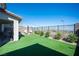 Well-maintained backyard featuring lush synthetic grass, putting green, and a cozy outdoor lounge area at 828 Parker Mesa St, Las Vegas, NV 89138