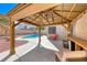 Backyard features a covered patio, pool, spa, palm trees, and desert landscaping at 9505 Belgate Ct, Las Vegas, NV 89129
