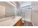 Modern bathroom with glass shower, vanity with quartz counters, wood cabinet, and updated fixtures at 9505 Belgate Ct, Las Vegas, NV 89129