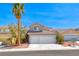 Charming two-story home featuring a two-car garage and landscaped front yard with a mature palm tree at 9505 Belgate Ct, Las Vegas, NV 89129