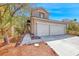 Inviting two-story home with a two-car garage, lush landscaping, and a welcoming walkway to the entrance at 9505 Belgate Ct, Las Vegas, NV 89129