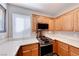 Contemporary kitchen with stainless steel range, microwave, light countertops, and wood cabinets at 9505 Belgate Ct, Las Vegas, NV 89129