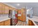 Spacious kitchen featuring stainless steel refrigerator and wood cabinets, with updated flooring and countertops at 9505 Belgate Ct, Las Vegas, NV 89129