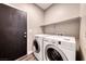 Functional laundry room with a door to the exterior and included washer and dryer at 9505 Belgate Ct, Las Vegas, NV 89129