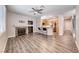 Open floor plan with fireplace, wood floors, ceiling fan, connecting living room and kitchen areas at 9505 Belgate Ct, Las Vegas, NV 89129