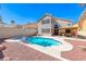 Backyard with a pool and spa, a covered patio, and a desert landscaped yard at 9505 Belgate Ct, Las Vegas, NV 89129
