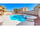 Backyard oasis features a pool and spa with desert landscaping and mature palm trees at 9505 Belgate Ct, Las Vegas, NV 89129