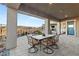 Covered patio with a dining table and chairs perfect for outdoor entertaining and desert views at 984 Edinburgh Fields Ct, Las Vegas, NV 89138