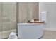 Spa-like bathroom featuring an oval soaking tub, walk-in shower and neutral colored tiles at 10739 Agate Cliffs Ave, Las Vegas, NV 89135