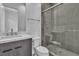 Modern bathroom with wood grain vanity, marble countertop, and walk-in glass shower featuring neutral tiling at 10739 Agate Cliffs Ave, Las Vegas, NV 89135