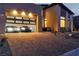 Exterior facade with two garages featuring a pair of modern sports cars parked on brick driveway with professional lighting at 10739 Agate Cliffs Ave, Las Vegas, NV 89135