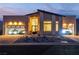 Spectacular home exterior showcasing modern garage doors, sports cars, a well-manicured yard, and a brick driveway at dusk at 10739 Agate Cliffs Ave, Las Vegas, NV 89135