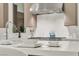 Modern kitchen detail showcasing the stainless steel faucet, cooktop, and white countertops at 10739 Agate Cliffs Ave, Las Vegas, NV 89135