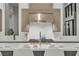 Close up of a modern kitchen featuring a stainless steel range and hood, and sleek white countertops at 10739 Agate Cliffs Ave, Las Vegas, NV 89135