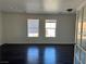 Open living room featuring wood-look flooring, a window, and a white-painted walls at 10799 Flame Vine Ct, Las Vegas, NV 89135