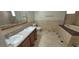 Bathroom featuring a dual sink vanity and tub with tiled walls and floors at 1301 Madison Ave, Las Vegas, NV 89106