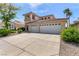Two-story home featuring a three-car garage, light-colored exterior, and well-manicured landscaping at 1339 Echo Creek St, Henderson, NV 89052