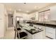 Clean kitchen features white cabinets, stainless appliances, and a black countertop with breakfast bar at 1339 Echo Creek St, Henderson, NV 89052