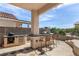 Entertain in style with an outdoor kitchen featuring a built-in grill, bar seating, and tiled accents at 1339 Echo Creek St, Henderson, NV 89052