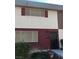 Two-story townhouse featuring neutral stucco, two windows and red trim at 146 Greenbriar Townhouse Way, Las Vegas, NV 89121