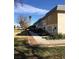 This exterior view showcases the front of the townhouses with a sidewalk and tree at 146 Greenbriar Townhouse Way, Las Vegas, NV 89121