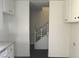 A clean hallway with stairs, complemented by white cabinets, offering a view to the upper level at 146 Greenbriar Townhouse Way, Las Vegas, NV 89121