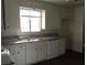 Galley kitchen features white cabinets, laminate countertops, and stainless steel appliances at 146 Greenbriar Townhouse Way, Las Vegas, NV 89121