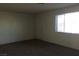 A bright living room features a window, a door, and neutral carpeting at 146 Greenbriar Townhouse Way, Las Vegas, NV 89121