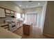 Bright kitchen featuring an island, tan tile flooring, plenty of cabinets, and a sliding glass door at 2100 Fred Brown Dr, Las Vegas, NV 89106