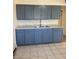 Features stainless sink, gray cabinets, and tile flooring at 2109 Glider St, North Las Vegas, NV 89030