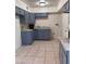 Galley style kitchen featuring painted cabinets, light countertops and tiled floors at 2109 Glider St, North Las Vegas, NV 89030