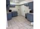Galley style kitchen featuring painted cabinets, light countertops and tiled floors at 2109 Glider St, North Las Vegas, NV 89030
