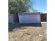 A fenced backyard with a metal storage shed, loose dirt, and shade at 2564 San Marcos St, Las Vegas, NV 89115