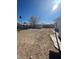 A backyard that features a chainlink fence, dirt, partial grass, and trees at 2564 San Marcos St, Las Vegas, NV 89115