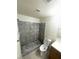A tiled bathroom with a toilet, mirror, vanity with storage, towel rack, and tiled walk in shower at 2564 San Marcos St, Las Vegas, NV 89115
