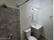 Tiled bathroom featuring a shower, toilet, sink, mirror, and overhead lighting at 2564 San Marcos St, Las Vegas, NV 89115