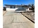 Front exterior showing the home with a driveway, white facade, and manicured front yard at 2564 San Marcos St, Las Vegas, NV 89115