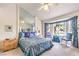 Sunlit bedroom with bay window, ceiling fan, mirrored wall, and floral bedding at 2608 Golfside Dr, Las Vegas, NV 89134