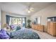 Bright bedroom featuring a large bay window, ceiling fan, and classic wooden furniture at 2608 Golfside Dr, Las Vegas, NV 89134