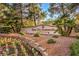Welcoming entrance to Sun City Summerlin with lush landscaping and colorful flower beds at 2608 Golfside Dr, Las Vegas, NV 89134
