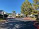 Well-maintained community street view featuring lush landscaping and inviting neighborhood charm under a bright blue sky at 2761 Lodestone Dr # 63, Las Vegas, NV 89117
