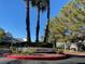 Entrance to Park Oasis features manicured landscaping, multiple palm trees and clear blue skies at 2761 Lodestone Dr # 63, Las Vegas, NV 89117