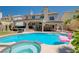 Inviting pool and patio area with a hot tub, outdoor seating, and lush landscaping at 2813 Via Avanti St, Henderson, NV 89074