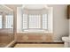 Bright bathroom featuring a soaking tub with glass block window and separate glass shower at 3330 Unicorn Ave, Pahrump, NV 89048