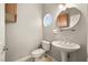 Charming powder room with pedestal sink, cabinet, round window, and updated fixtures at 3330 Unicorn Ave, Pahrump, NV 89048