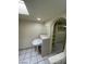 Bathroom boasting a pedestal sink, tile countertop, and an arched doorway to a closet at 3797 Monument St, Las Vegas, NV 89121