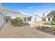 Elegant white home featuring a covered walkway, brick driveway, and mature landscaping at 3938 E Russell Rd, Las Vegas, NV 89120