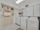 Bright laundry room features white cabinetry, appliances and plenty of storage space at 3938 E Russell Rd, Las Vegas, NV 89120