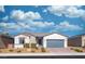 Charming single-story home with desert landscaping and a gray two car garage door at 4400 E Cactus Canyon Dr, Pahrump, NV 89061