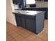 Close up of the kitchen featuring dark blue cabinets, a breakfast bar, and tile flooring at 4508 W San Miguel Ave, North Las Vegas, NV 89032